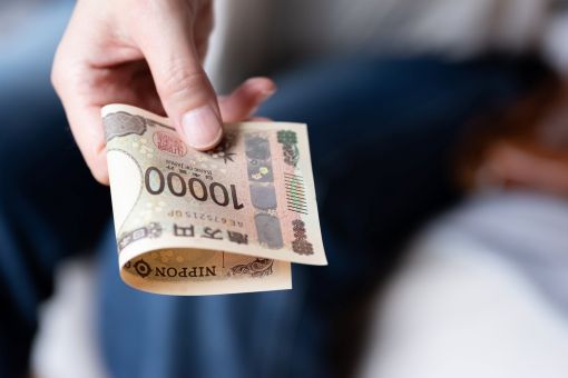 1万円札を持つ男性の手